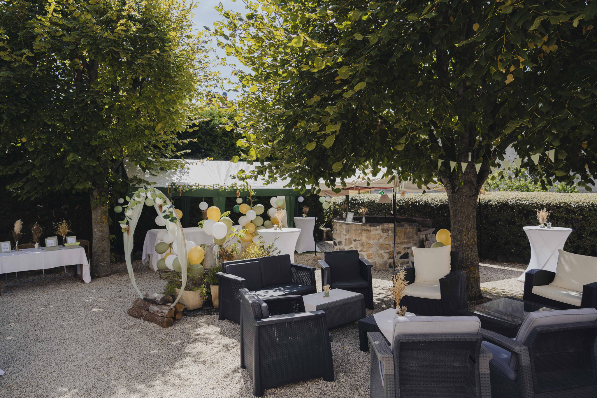 Outdoor space of a property with armchairs and festive decoration, surrounded by trees.