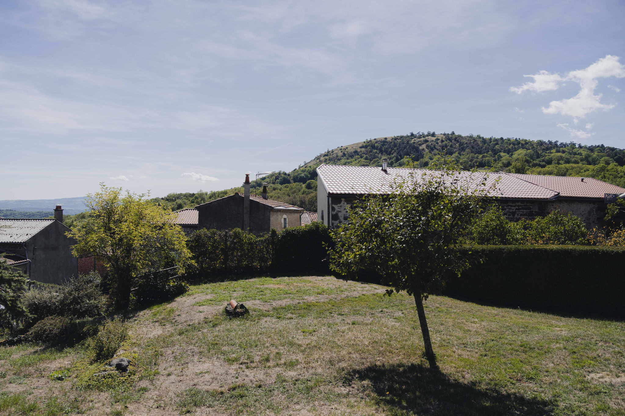 View of a renovated old farmhouse with a garden and mountains in the background in Olloix.