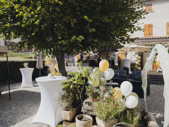 Terrace of a renovated old farmhouse with tables and chairs, decorated with balloons, in Olloix.