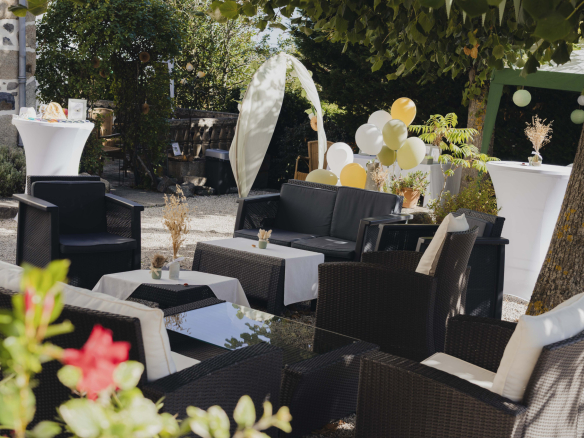 Terrace furnished with armchairs and tables, decorated for an outdoor event.