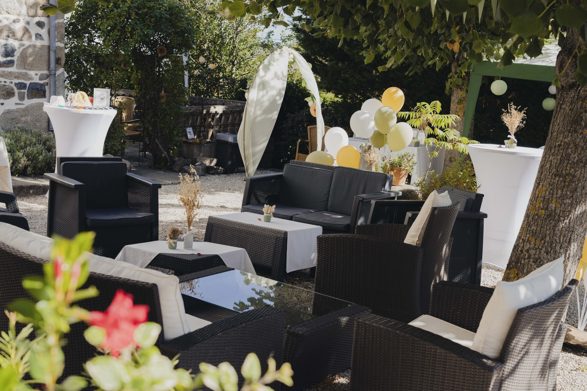 Terrace furnished with armchairs and tables, decorated for an outdoor event.