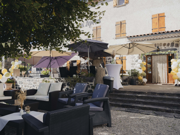 Terrace of a renovated old farmhouse with parasols and garden furniture, Olloix.