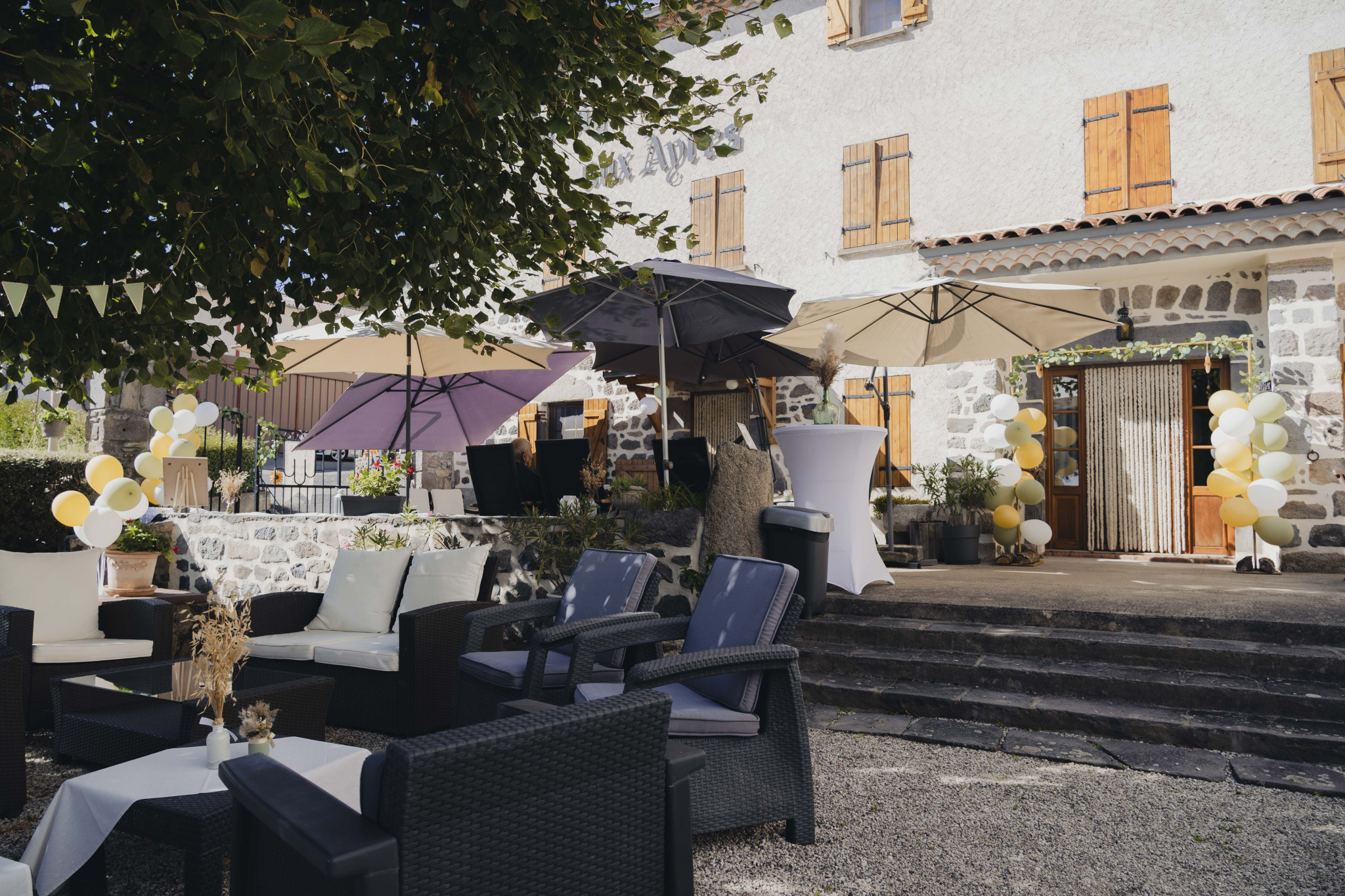 Terrace of a renovated old farmhouse with parasols and garden furniture, Olloix.