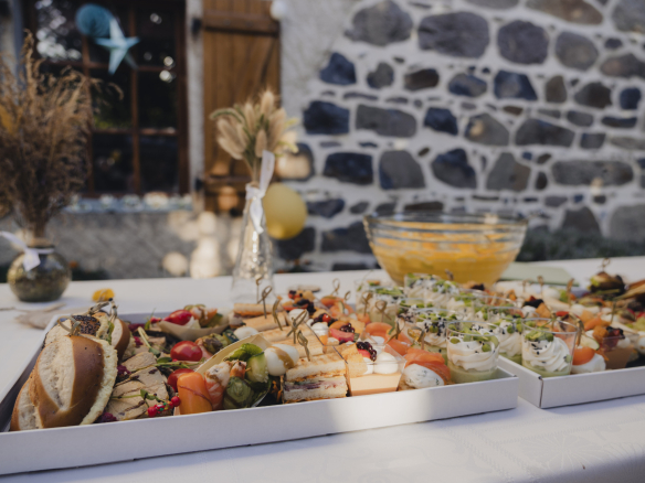 A platter of assorted hors d'oeuvres with vegetables, meats and sauces, on an outdoor table.