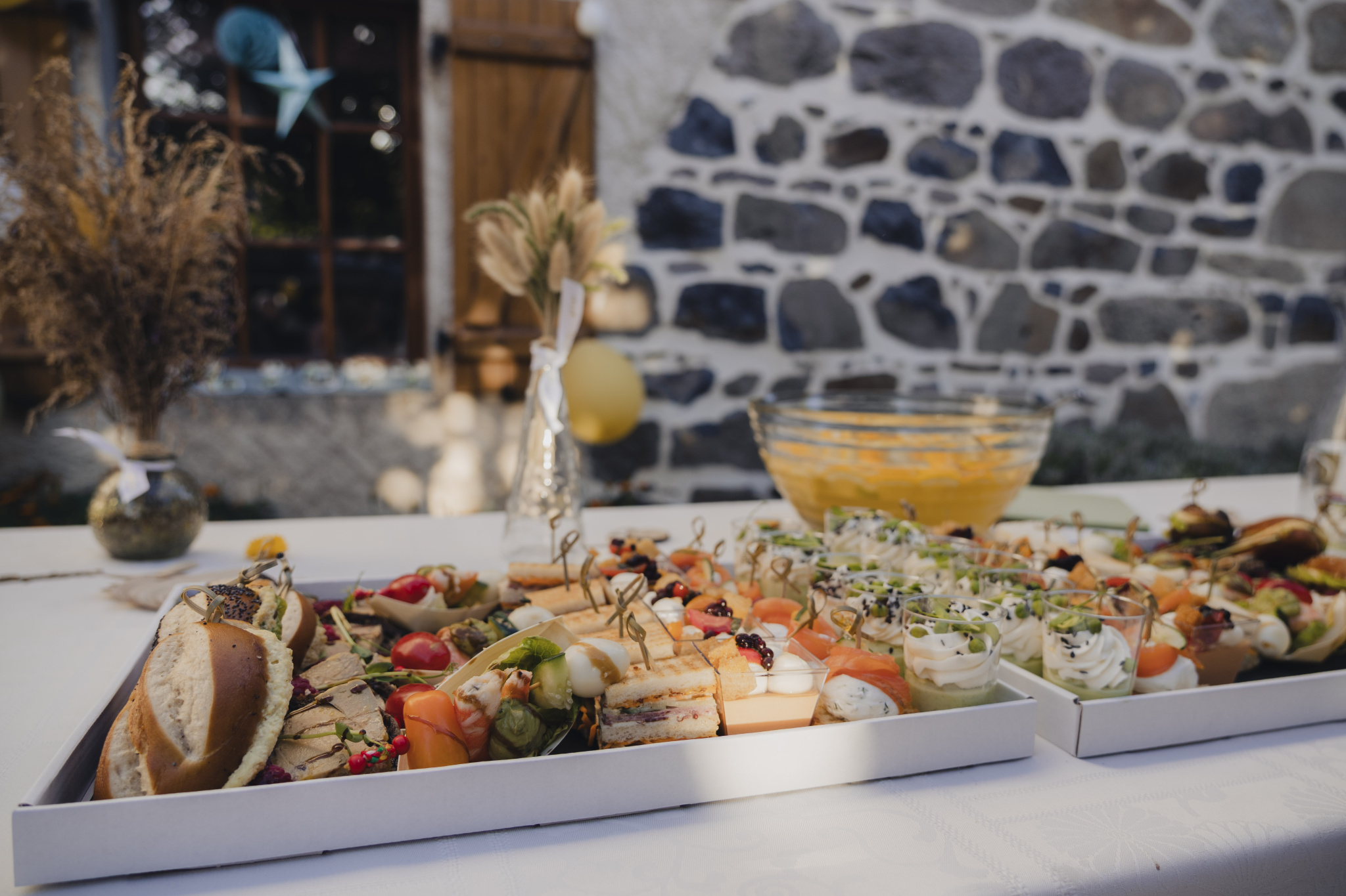 A platter of assorted hors d'oeuvres with vegetables, meats and sauces, on an outdoor table.
