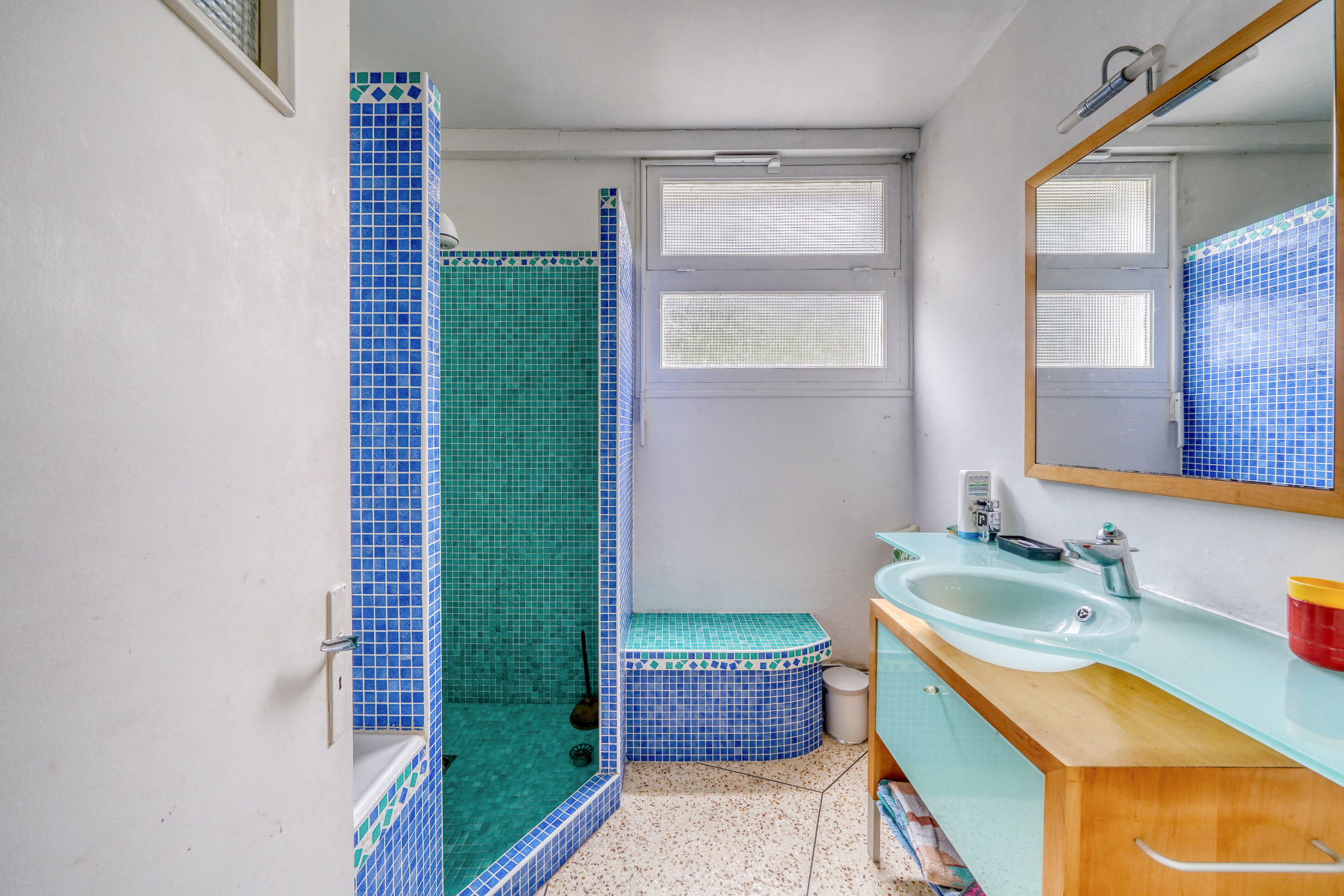 Renovated bathroom Bathroom with shower and sink, blue and white tiles, natural light
