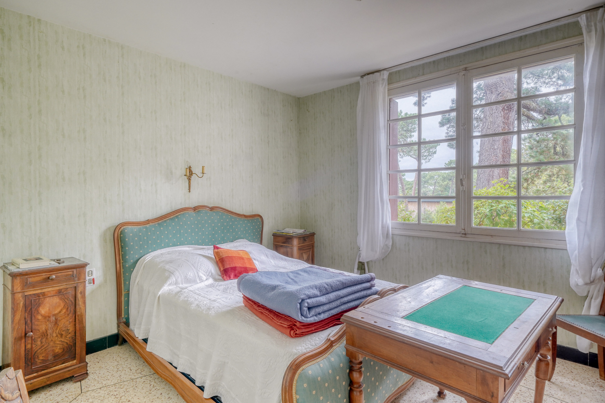 Room to renovate Room in a house to be renovated with bed, table and window overlooking the outside.