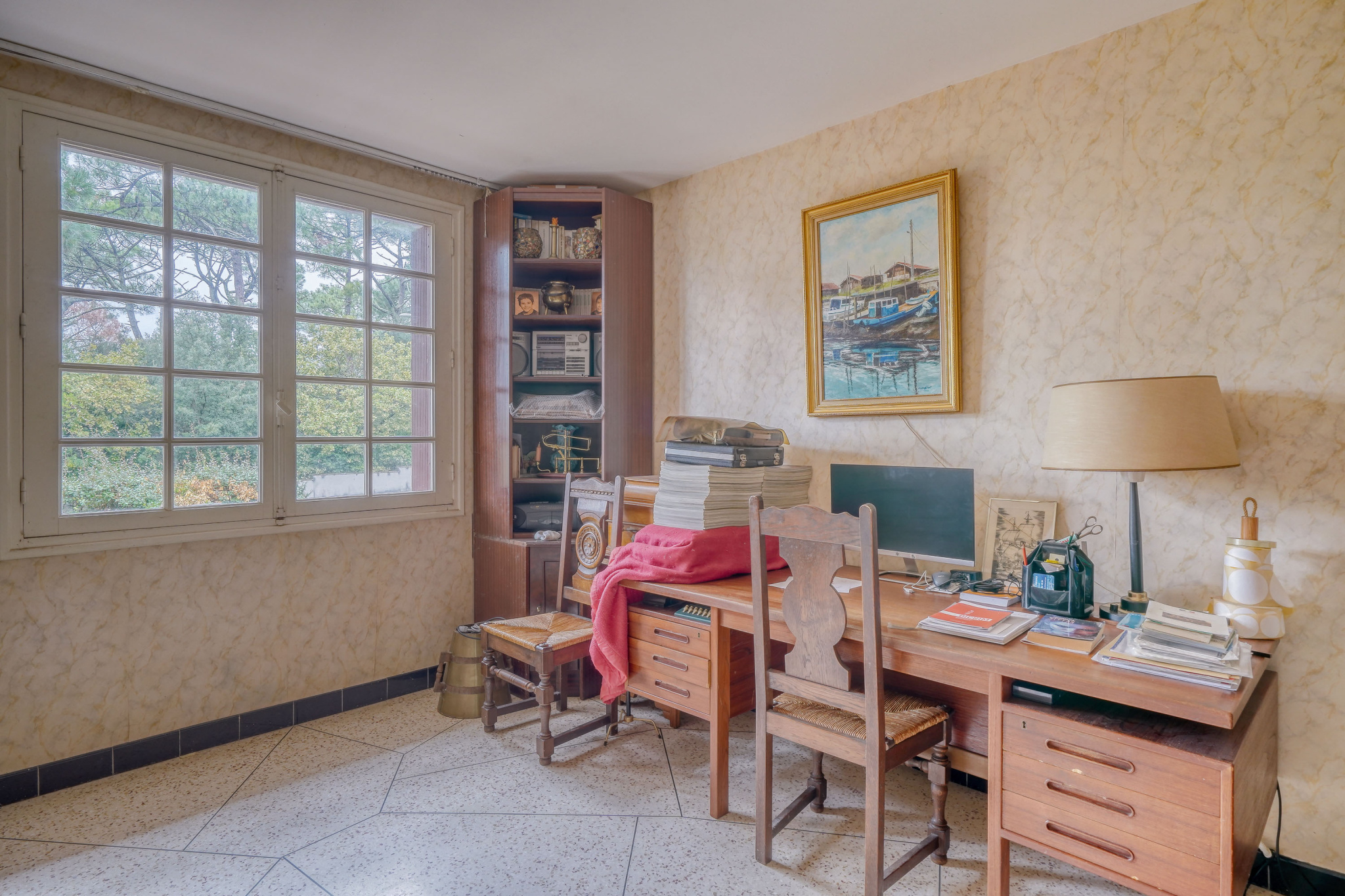 Office in a house to be renovated in La Teste-de-Buch Office with wooden furniture and a window overlooking the outside in a house to be renovated.