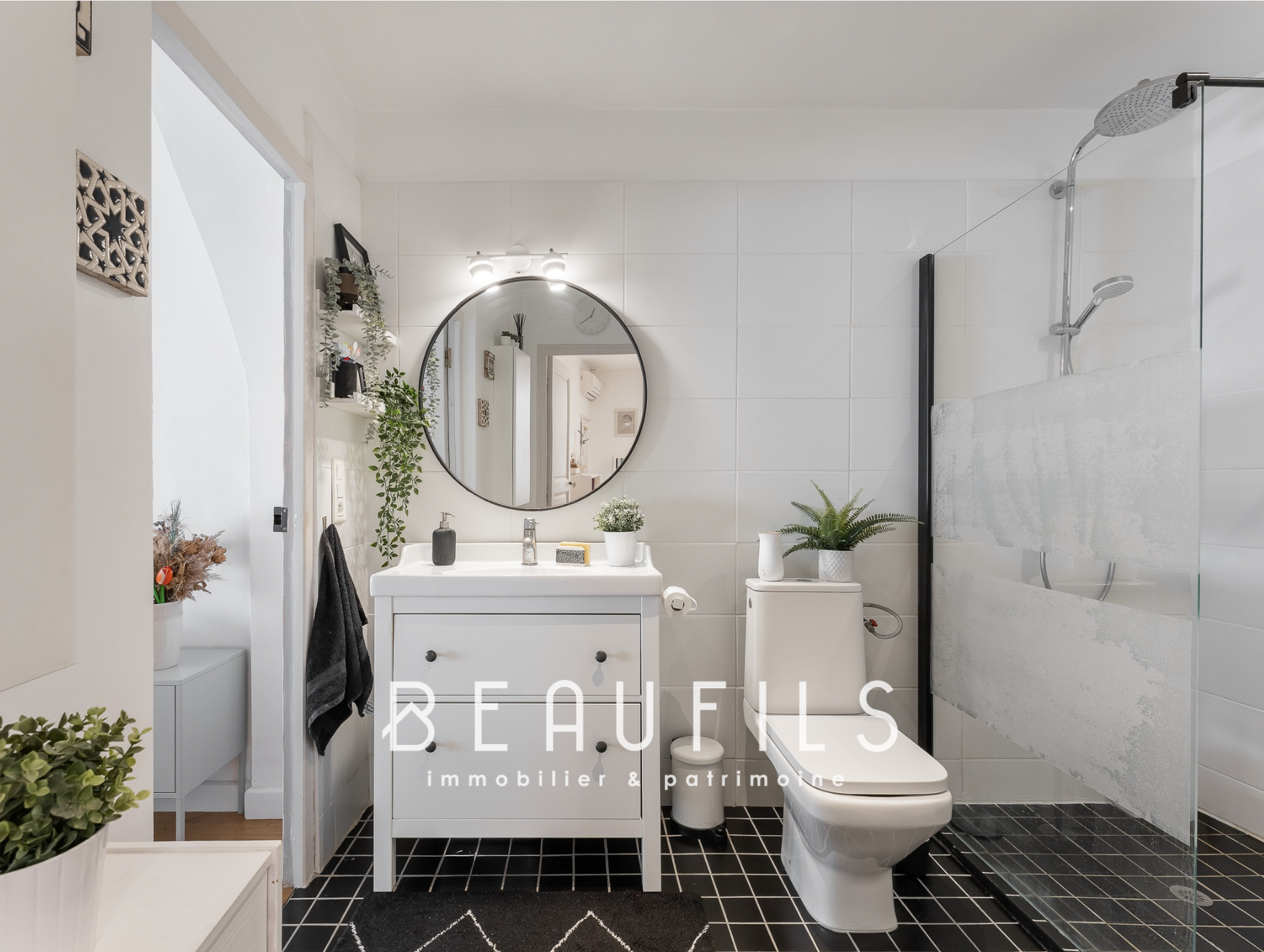 Salle de bain rénovée Salle de bain moderne avec lavabo, miroir rond et douche, décoration minimaliste.
