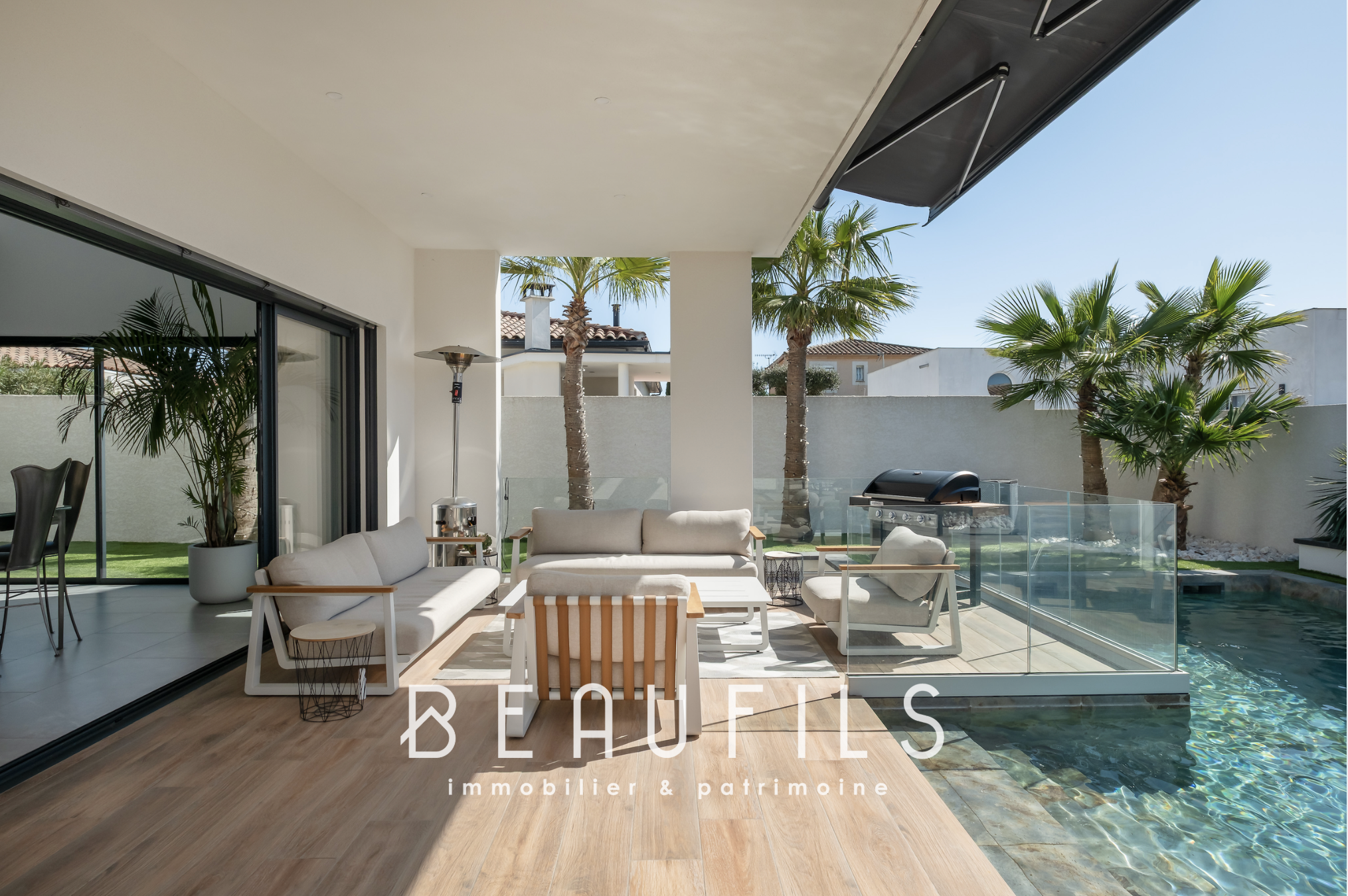 terrace of a contemporary villa Terrace of a contemporary villa with swimming pool and outdoor furniture, surrounded by palm trees.