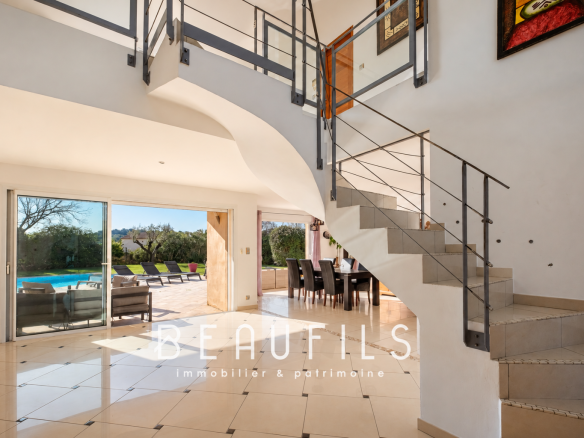 Interior of an architect-designed villa with a modern staircase and a large, bright living room.