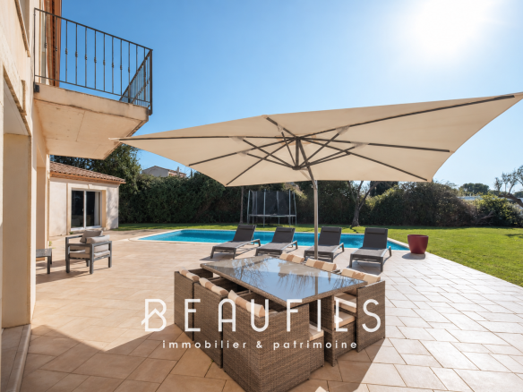 Terrace of an architect-designed villa with swimming pool in Nîmes, sun loungers and parasol.