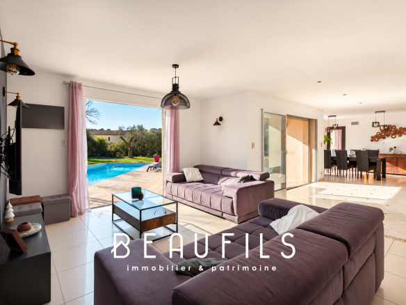 Interior of a modern villa with living room, open kitchen and access to the terrace and swimming pool.