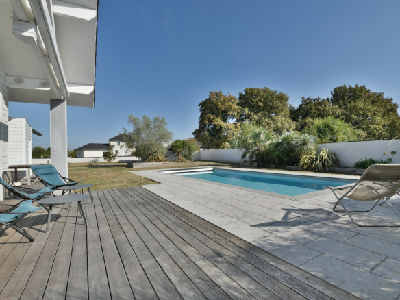 Piscine chauffée de 9x4 m entourée de chaises longues et d'un espace vert à Buros.