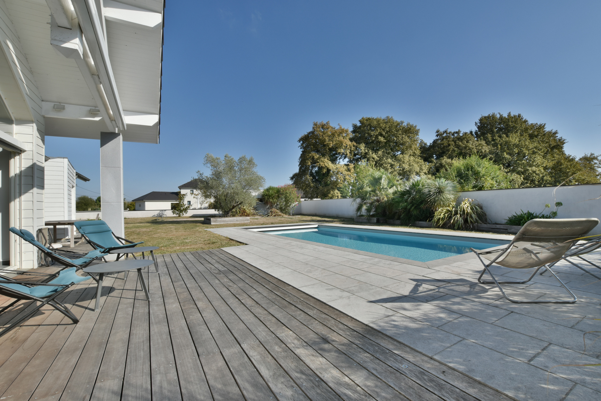 Piscine contemporaine à Buros Piscine chauffée de 9x4 m entourée de chaises longues et d'un espace vert à Buros.