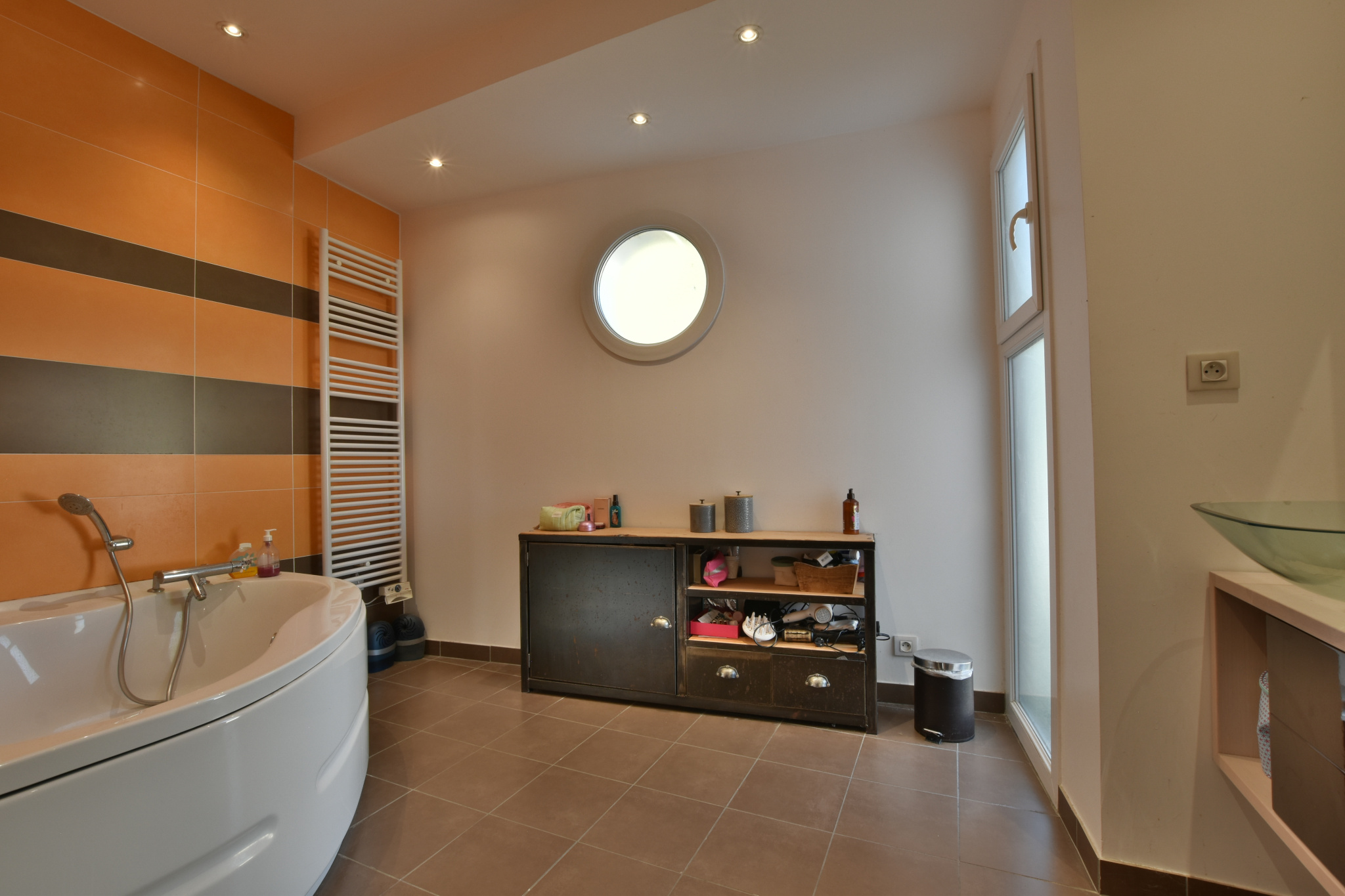 Salle de bain contemporaine Salle de bain moderne avec baignoire et rangement, murs orange et blancs.