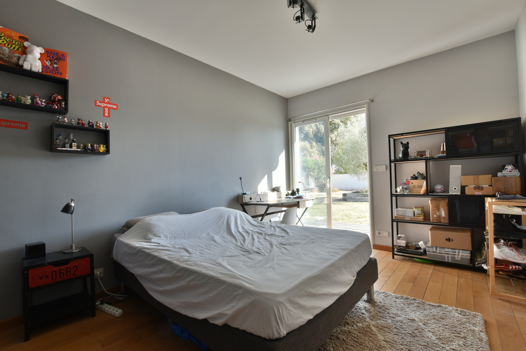 Chambre contemporaine Chambre d'une maison moderne avec un lit, un bureau et une baie vitrée donnant sur l'extérieur.