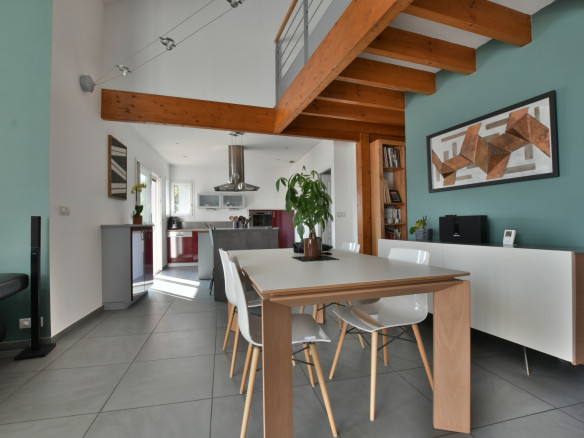 Intérieur moderne d'une maison avec salle à manger et cuisine ouverte, décorée de manière contemporaine.