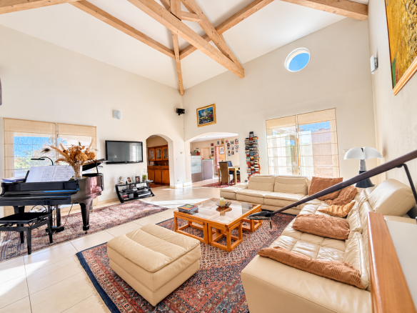 Intérieur d'une maison de plain-pied avec salon lumineux et piano.