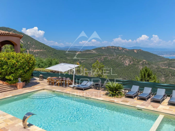 Villa avec piscine chauffée et vue sur la mer à Théoule-sur-Mer, entourée de verdure.