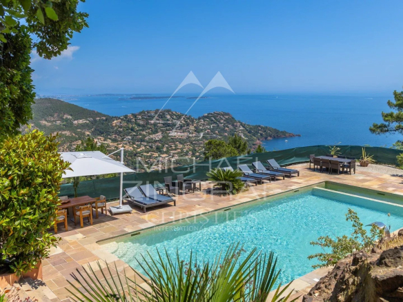 Vue d'une villa avec piscine chauffée et mer en arrière-plan, située à Théoule-sur-Mer.