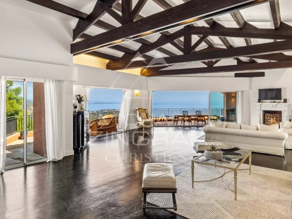Intérieur d'une villa moderne avec vue sur la mer, salon spacieux et lumineux.