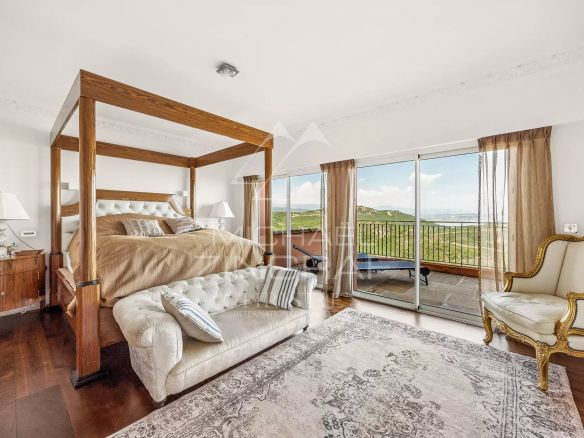 Chambre d'une villa avec lit à baldaquin et vue sur la mer à Théoule-sur-Mer.