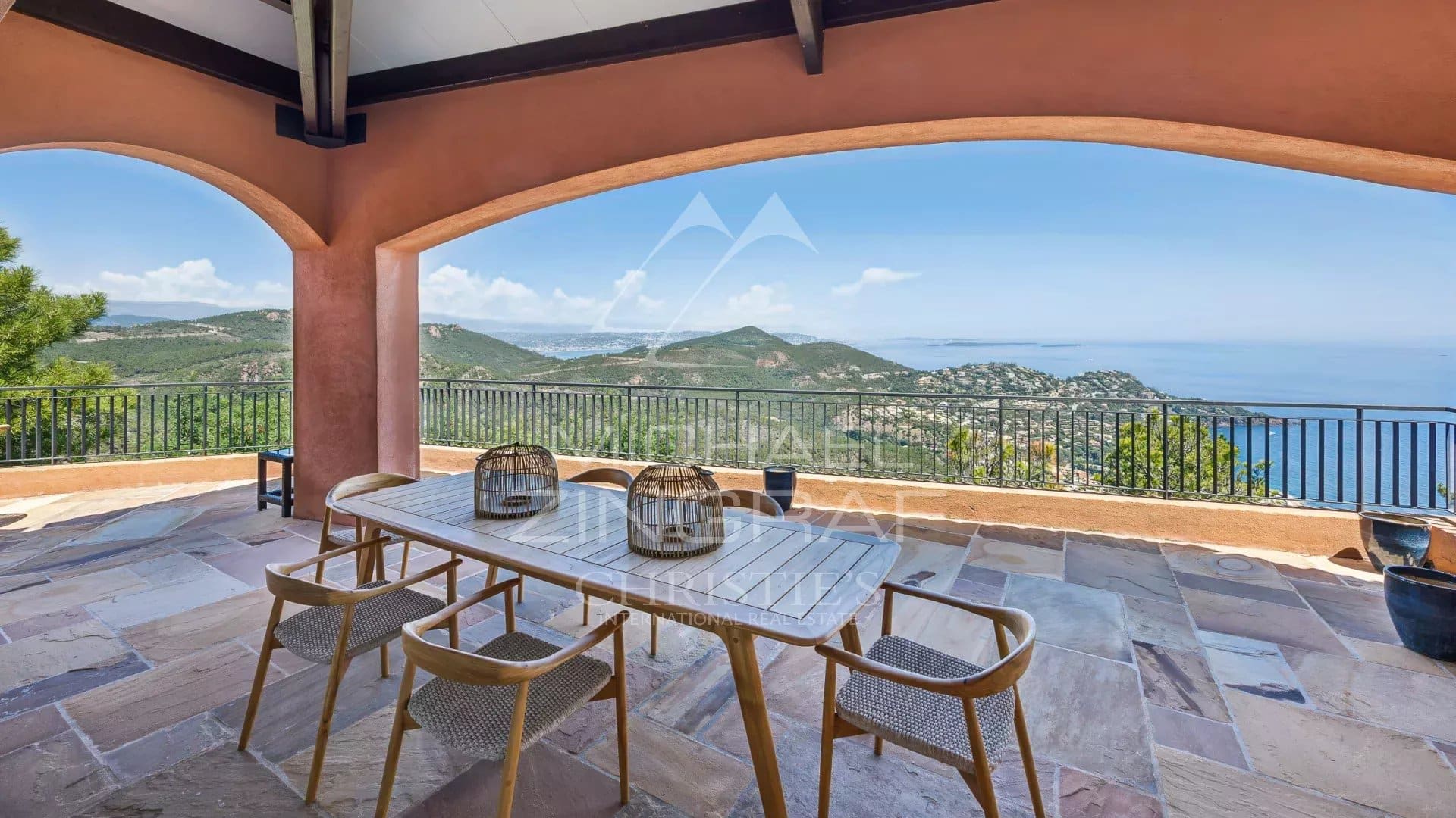 Terrasse avec vue à Théoule-sur-Mer Terrasse avec vue sur la mer et les montagnes, mobilier extérieur en bois, villa à Théoule-sur-Mer.