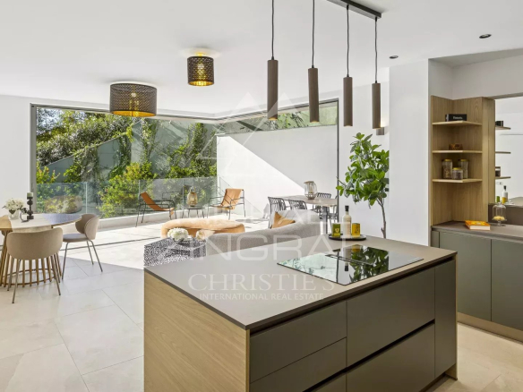 Intérieur d'un appartement moderne avec cuisine ouverte et salle à manger, baigné de lumière naturelle.
