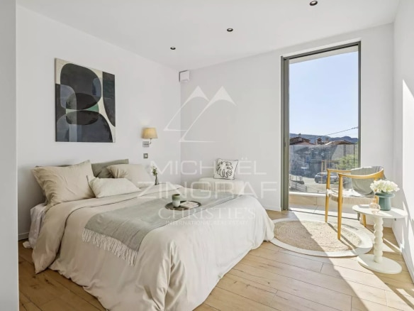 Chambre lumineuse avec lit double et accès à un balcon, appartement moderne à Mandelieu-la-Napoule.