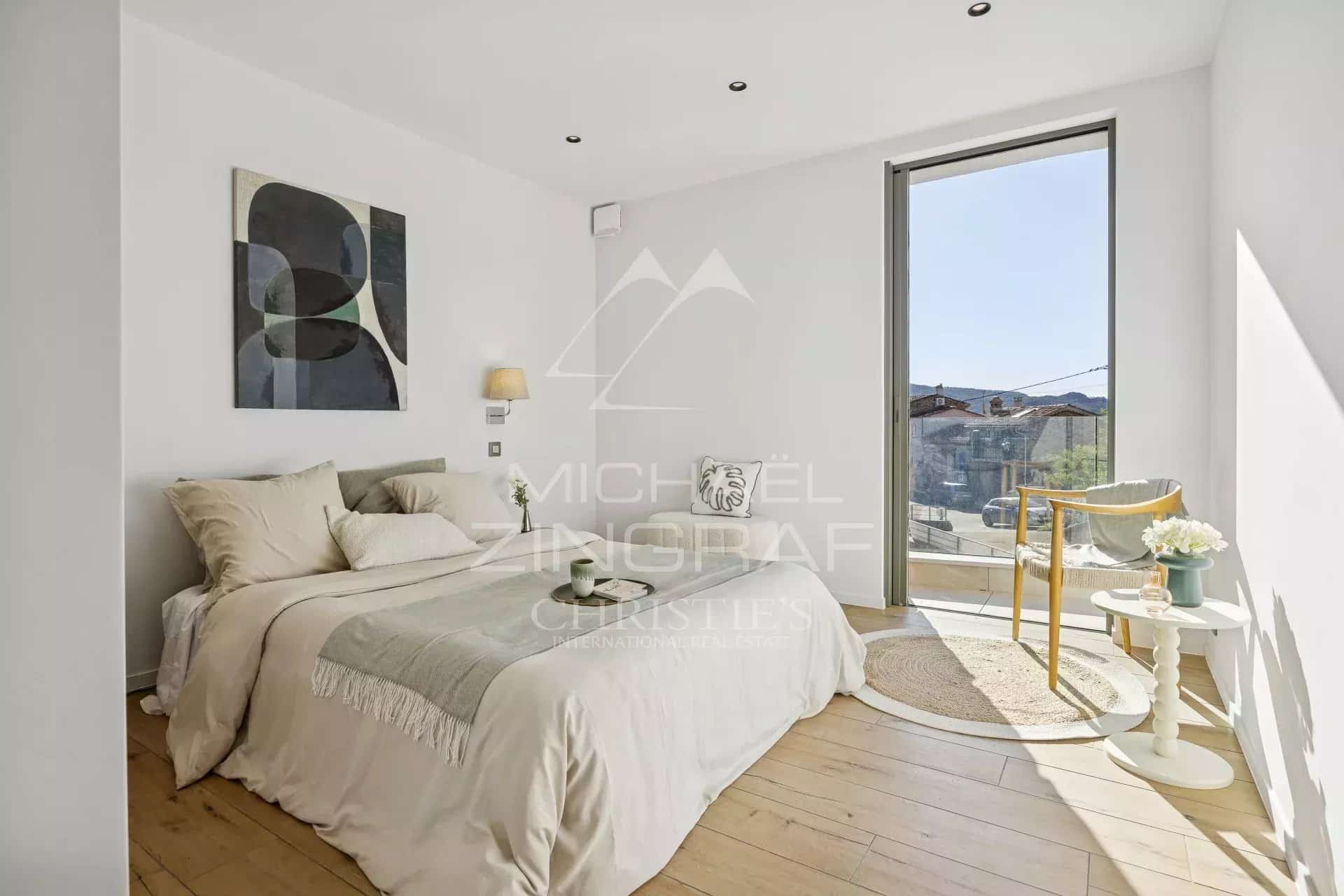 Chambre lumineuse avec lit double et accès à un balcon, appartement moderne à Mandelieu-la-Napoule.