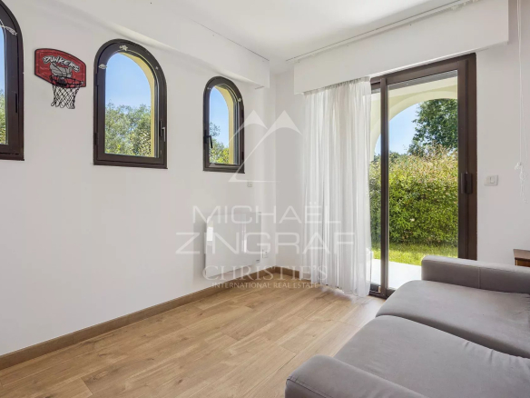 Intérieur d'un appartement avec canapé et fenêtres donnant sur l'extérieur