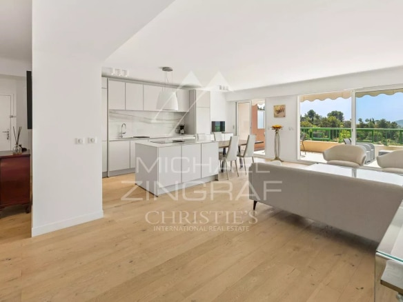 Intérieur d'un appartement lumineux avec cuisine ouverte et salon, vue sur la nature à Mandelieu-la-Napoule.
