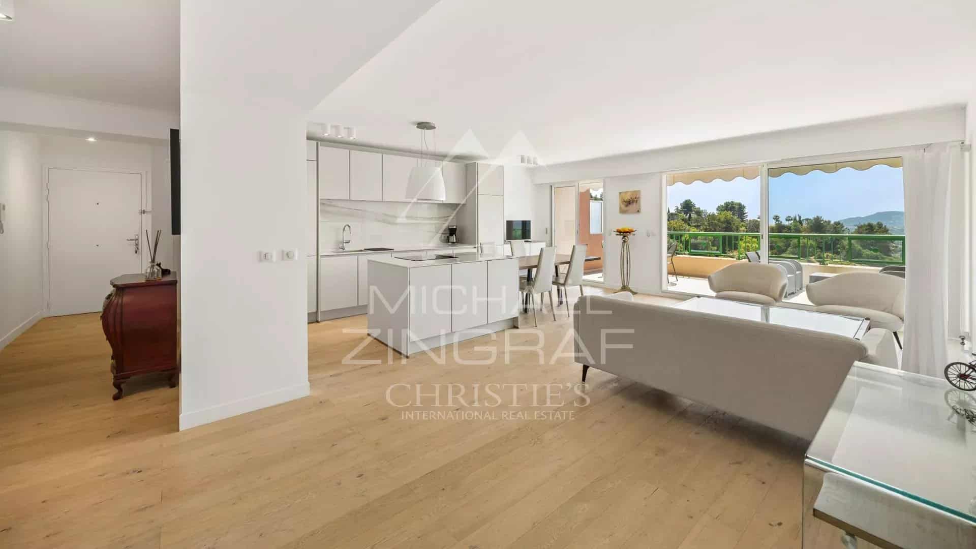 Intérieur d'un appartement lumineux avec cuisine ouverte et salon, vue sur la nature à Mandelieu-la-Napoule.