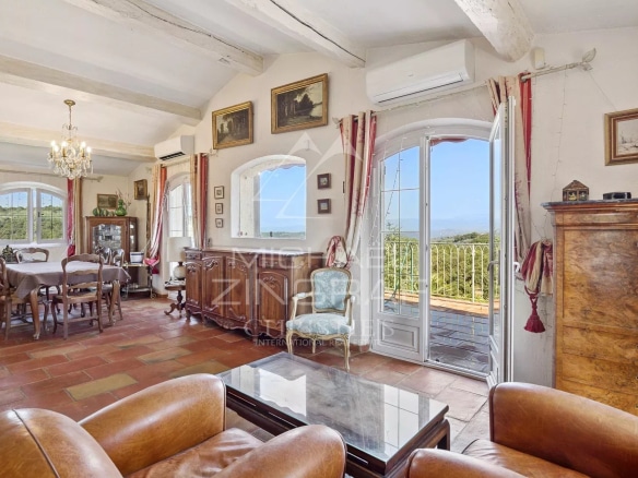 Interior of a house in Mandelieu-la-Napoule with living room and dining room, view of the hills.