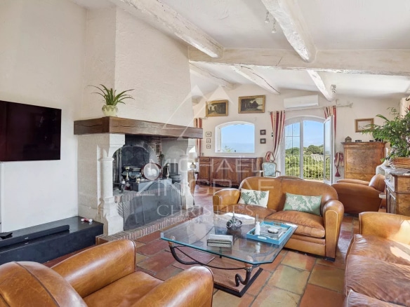 Bright living room with fireplace, leather sofas and views of the hills.