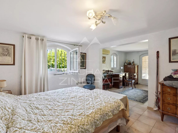 Bedroom in a family home in Mandelieu-la-Napoule with bed and wooden furniture.