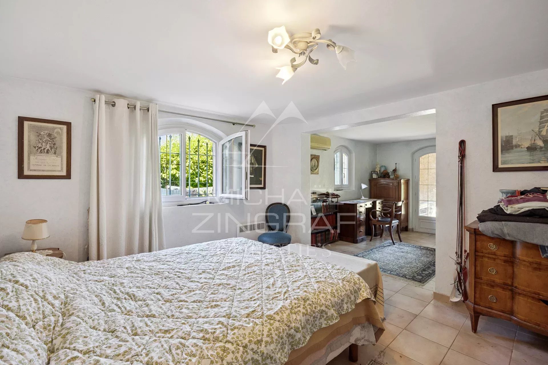 Bedroom in a family home in Mandelieu-la-Napoule with bed and wooden furniture.