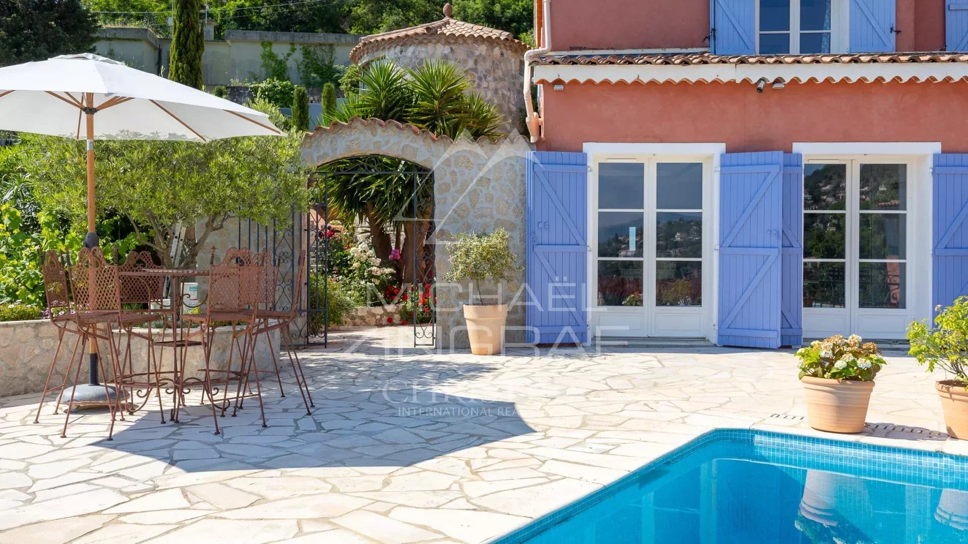 Terrasse ensoleillée avec piscine et mobilier extérieur, maison de charme à Mandelieu-la-Napoule.