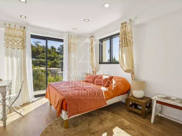 Modern room with orange bed and window overlooking a garden in Mandelieu-la-Napoule.