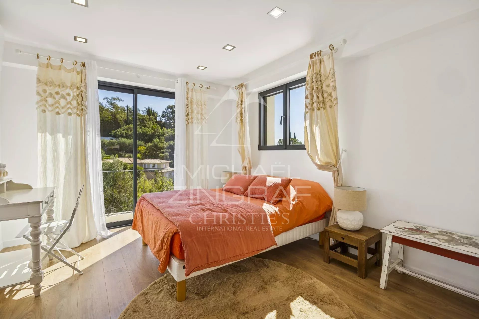Modern room with orange bed and window overlooking a garden in Mandelieu-la-Napoule.