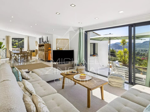 Interior of a renovated modern villa with panoramic views, bright living room and contemporary furniture.
