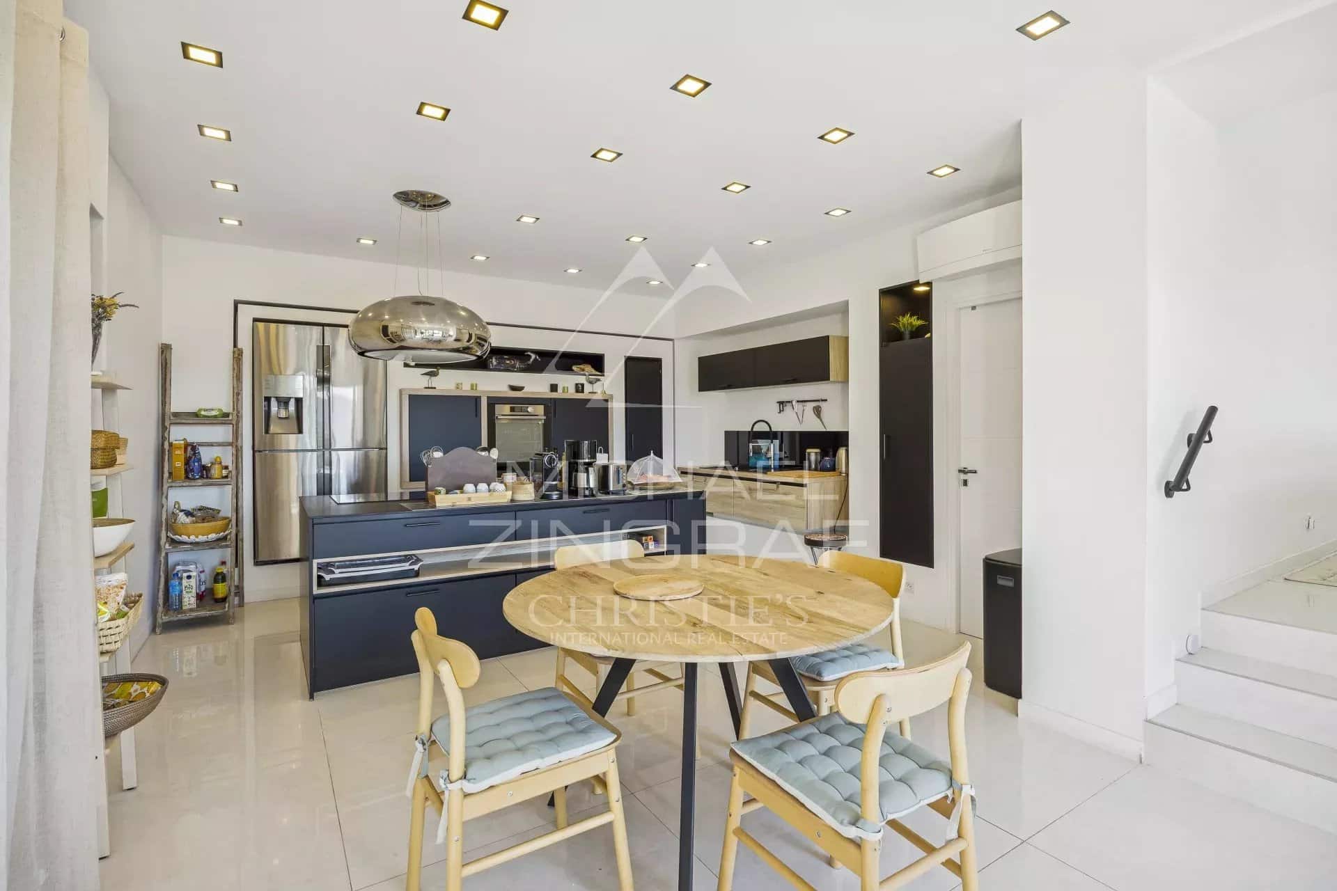 Modern and bright kitchen in a renovated villa in Mandelieu-la-Napoule, with table and chairs.