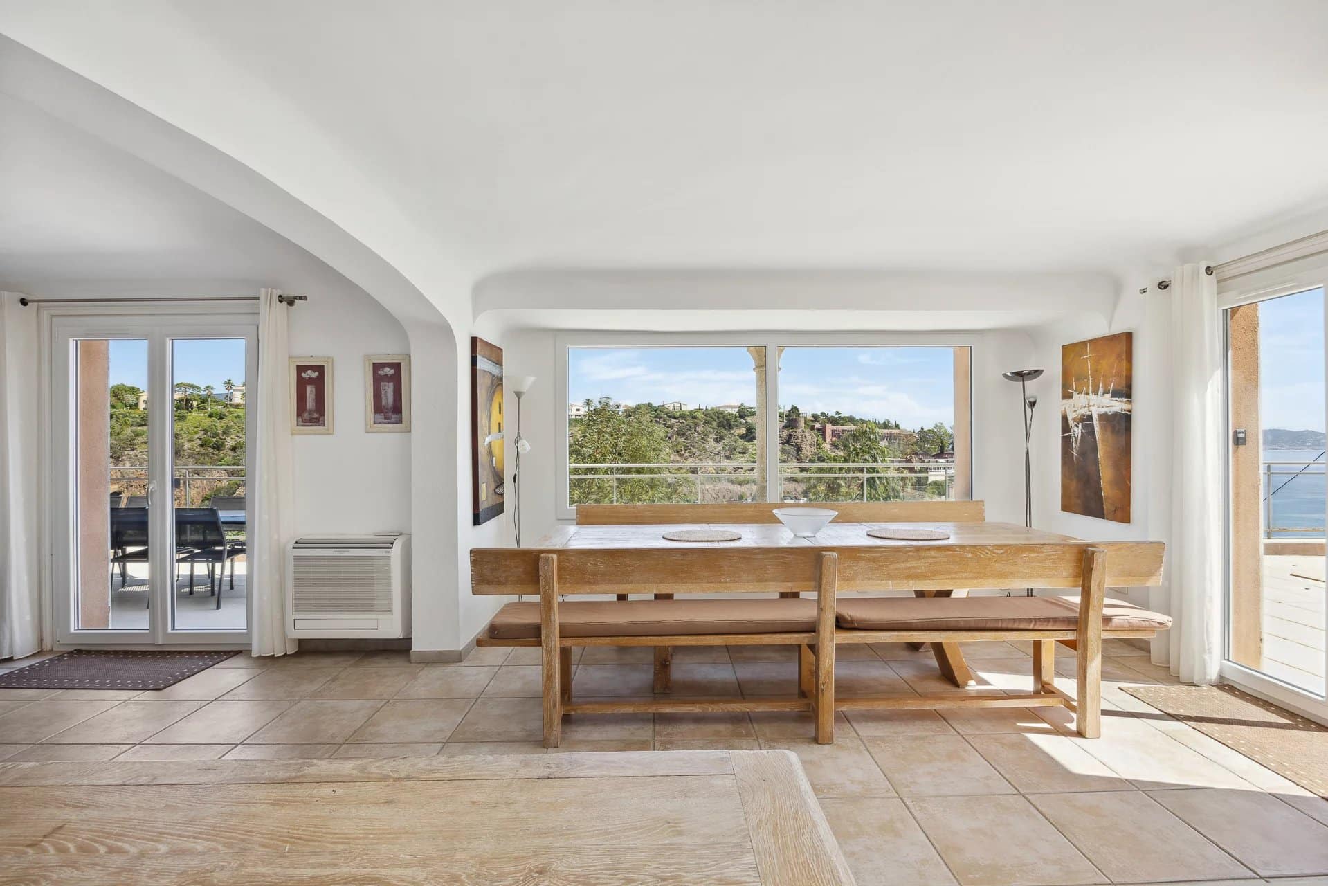 Intérieur d'une maison à Théoule-sur-Mer avec une salle à manger lumineuse et vue sur la mer.