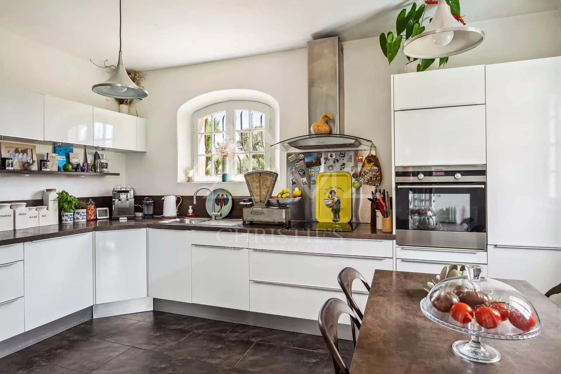 Cuisine moderne et lumineuse avec meubles blancs et plan de travail en noir.