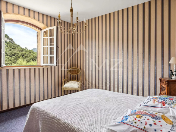 Chambre avec fenêtre et décoration à rayures, vue sur la nature à Mandelieu-la-Napoule.