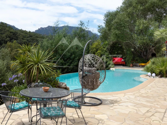 Terrasse avec piscine et mobilier extérieur dans un jardin verdoyant
