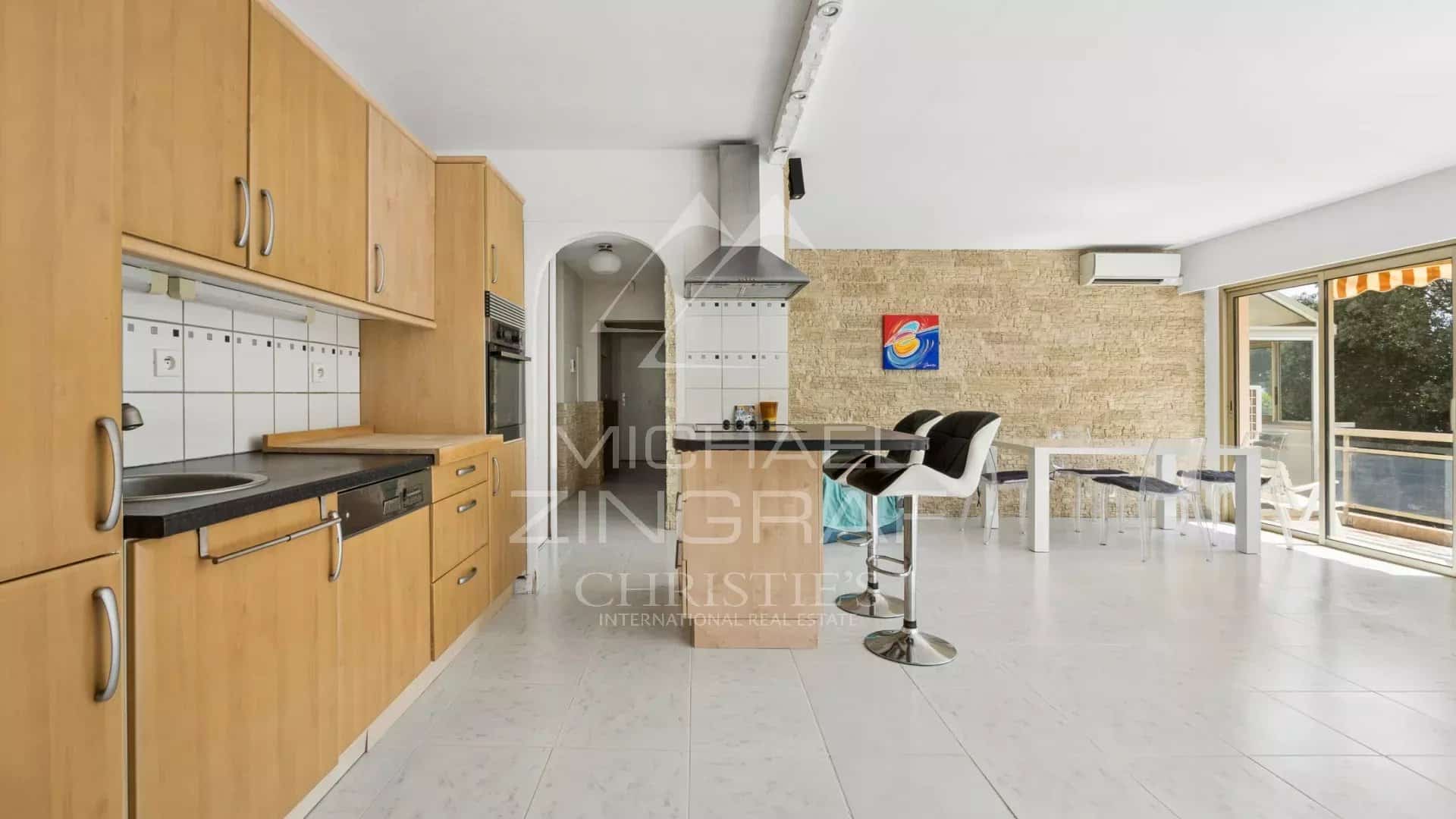 Intérieur d'un appartement lumineux avec cuisine ouverte et espace de vie, situé à Mandelieu-la-Napoule.