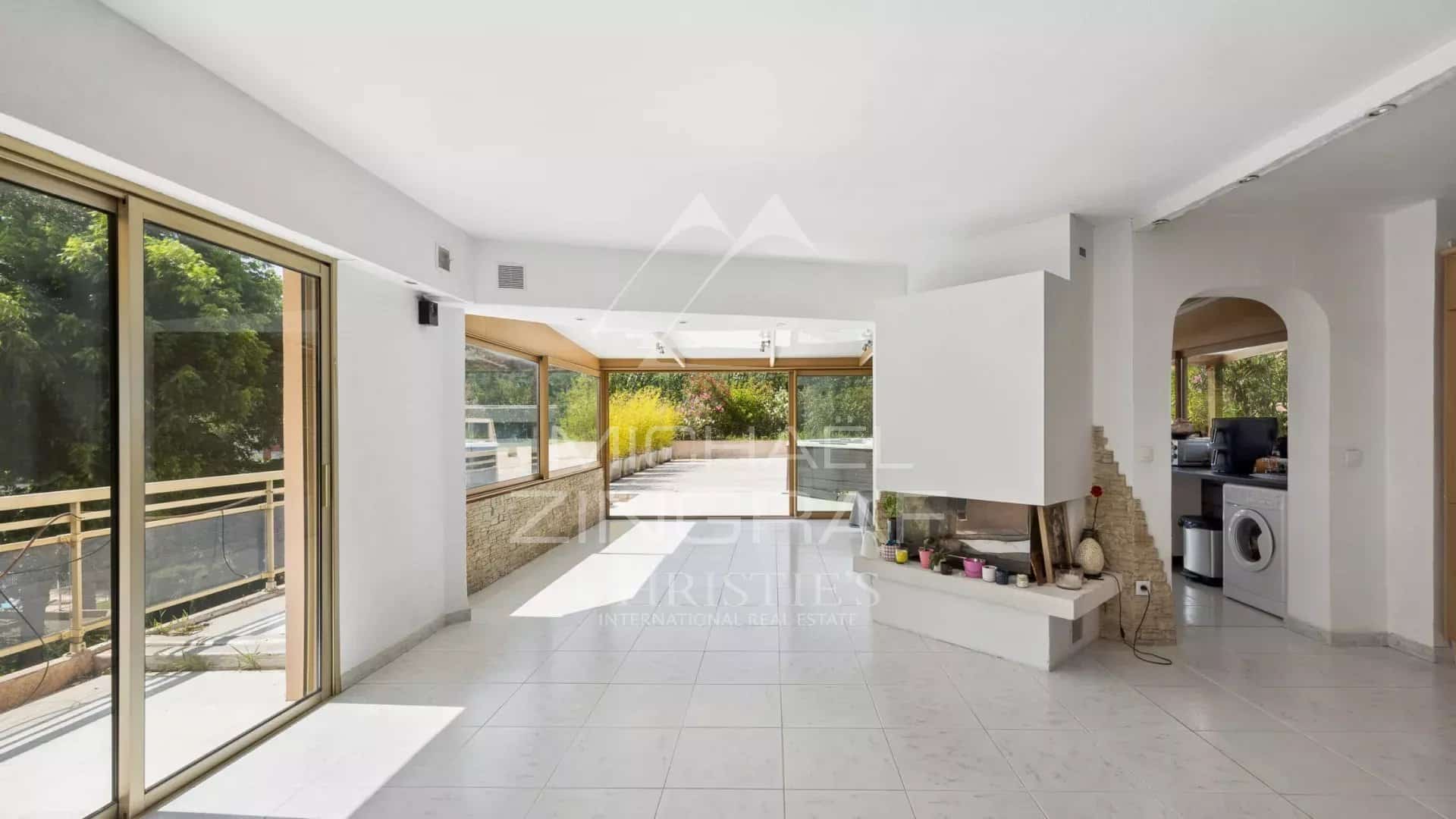 Intérieur d'un appartement lumineux avec séjour spacieux et cuisine ouverte, fenêtres sur terrasse.
