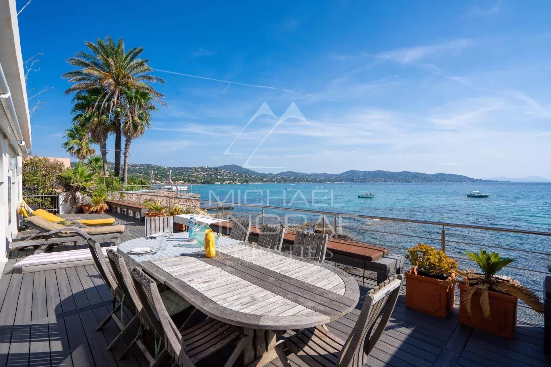 Terrasse en bois avec table et chaises, vue sur la mer à Sainte-Maxime